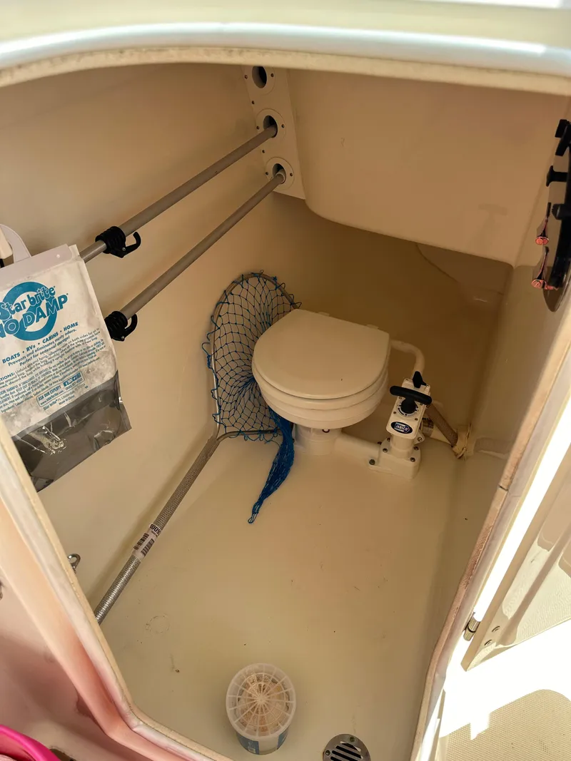 Slide: The Image of 2014 Scout 245 Dorado boat interior with compact marine toilet and storage features. - 19