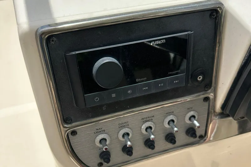 Slide: The Image of Control panel of a 2014 Scout 245 Dorado boat with audio system and switches. - 22