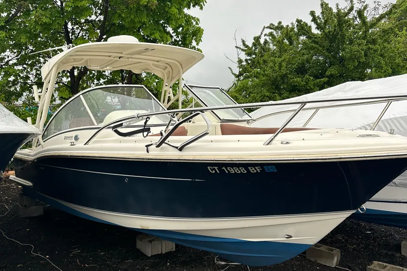 Slide: The Image of 2014 Scout 245 Dorado boat with canopy, parked on blocks, surrounded by trees. - 6