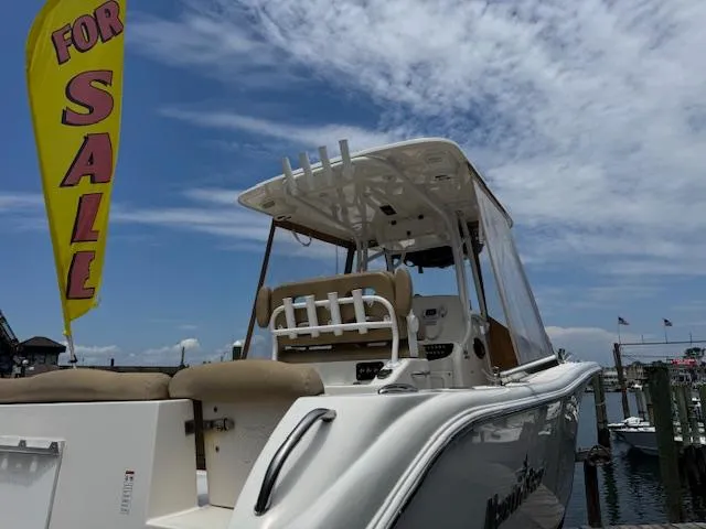 Slide: The Image of 2020 NauticStar 2602 Legacy boat for sale at marina, under clear blue sky. - 11