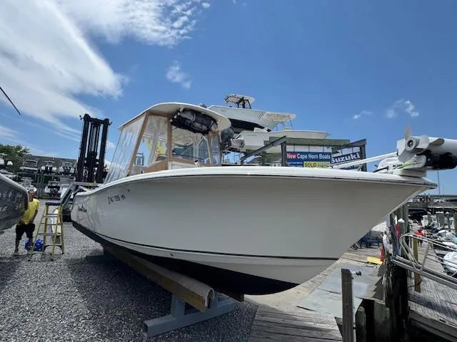 Slide: The Image of 2020 NauticStar 2602 Legacy boat on display at a marina under a clear blue sky. - 16