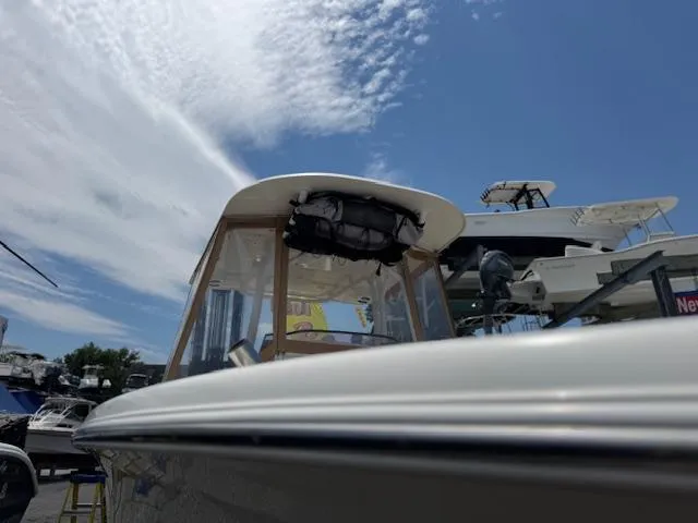 Slide: The Image of 2020 NauticStar 2602 Legacy boat under clear blue sky at marina. - 17