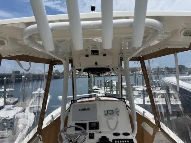 Slide: The Image of 2020 NauticStar 2602 Legacy boat interior with helm, docked at marina. - 19