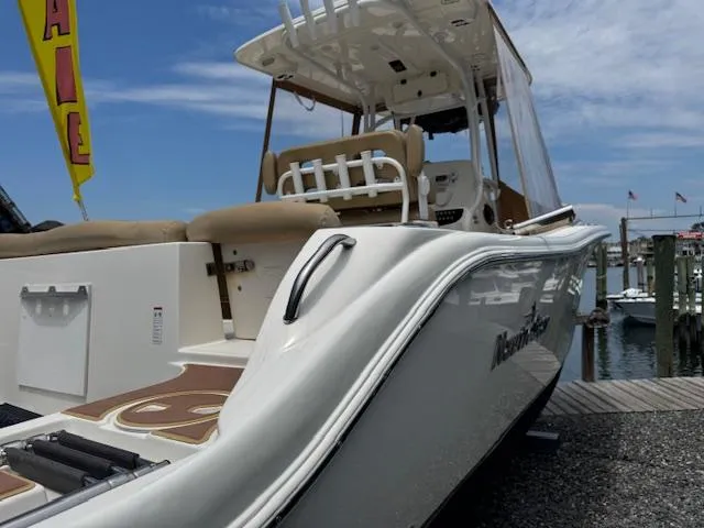 Slide: The Image of 2020 NauticStar 2602 Legacy boat docked, showcasing sleek design and comfortable seating. - 2