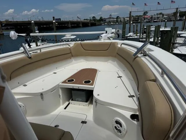 Slide: The Image of 2020 NauticStar 2602 Legacy boat with spacious seating and storage, docked at a marina. - 21