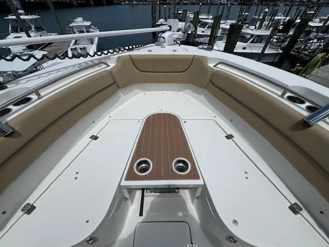 Slide: The Image of 2020 NauticStar 2602 Legacy boat interior with cushioned seating and wooden deck accents. - 22