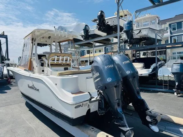 Slide: The Image of 2020 NauticStar 2602 Legacy boat with dual Yamaha 150 engines in a marina setting. - 7