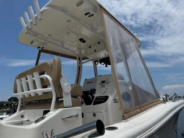 Slide: The Image of 2020 NauticStar 2602 Legacy boat with helm station and seating under a clear sky. - 9