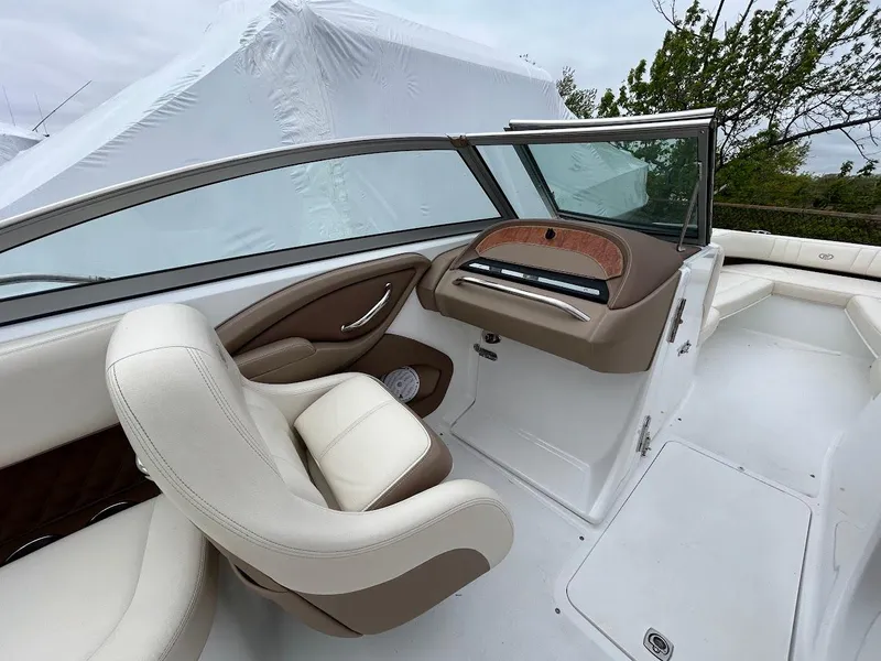 Slide: The Image of 2010 Cobalt 262 boat interior with white and brown seating, sleek dashboard, and windshield. - 10