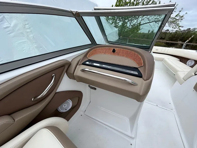 Slide: The Image of 2010 Cobalt 262 boat interior with beige and white seating, dashboard, and windshield. - 11