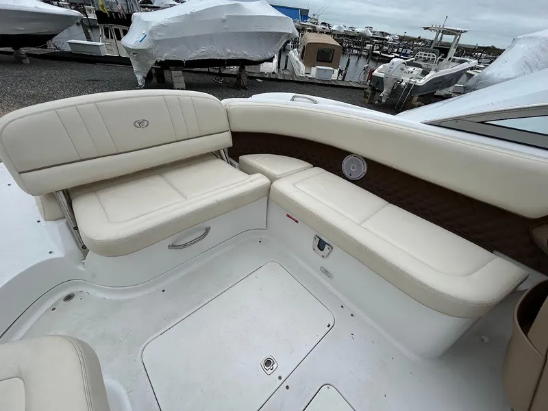 Slide: The Image of 2010 Cobalt 262 boat interior with beige seating, docked at a marina. - 14