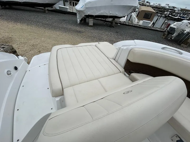 Slide: The Image of 2010 Cobalt 262 boat with beige leather seating at a marina. - 16