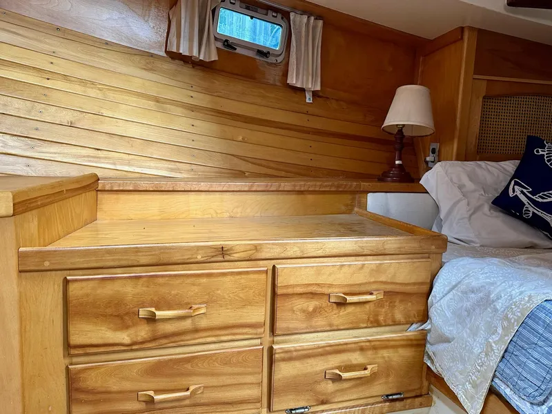 Slide: The Image of Cozy 1989 Pilgrim Trawler cabin with wooden drawers and nautical-themed decor. - 13