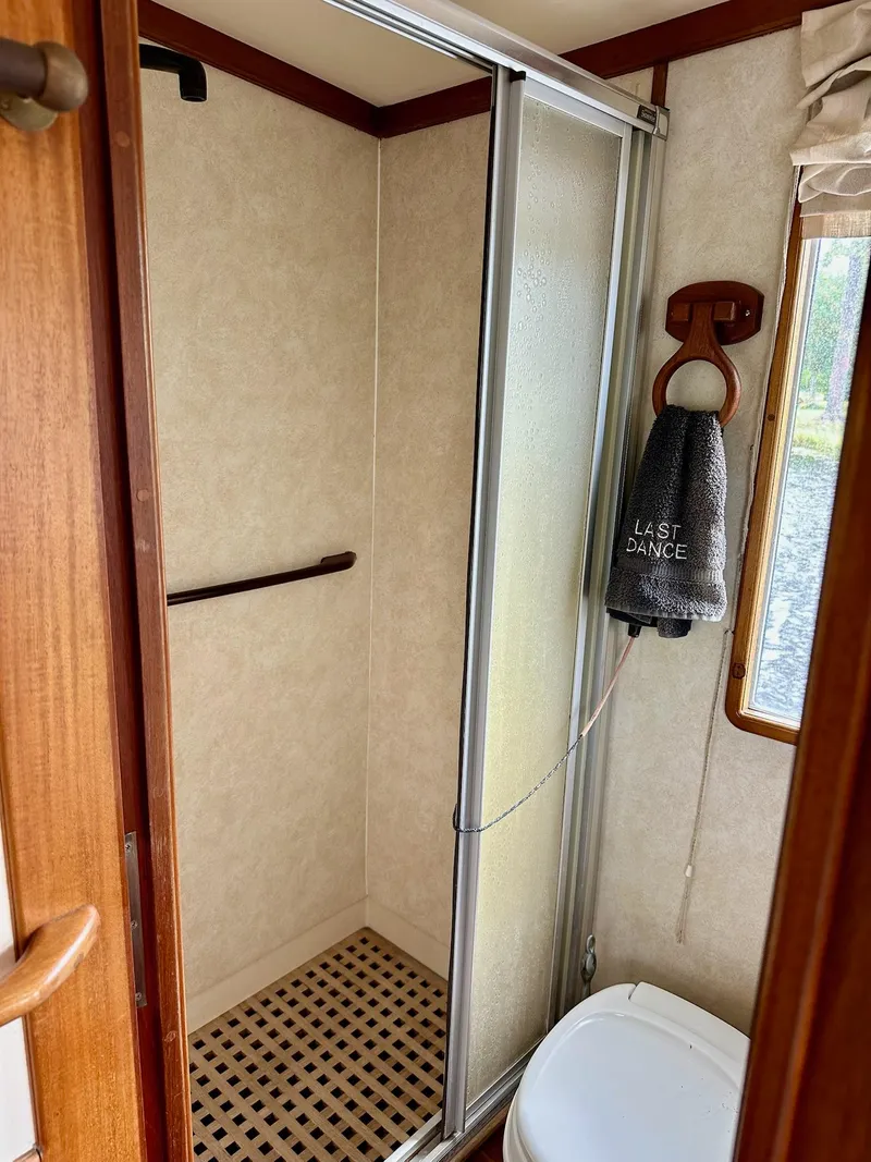 Slide: The Image of Bathroom interior of 1989 Pilgrim Trawler with shower and towel labeled "Last Dance." - 16