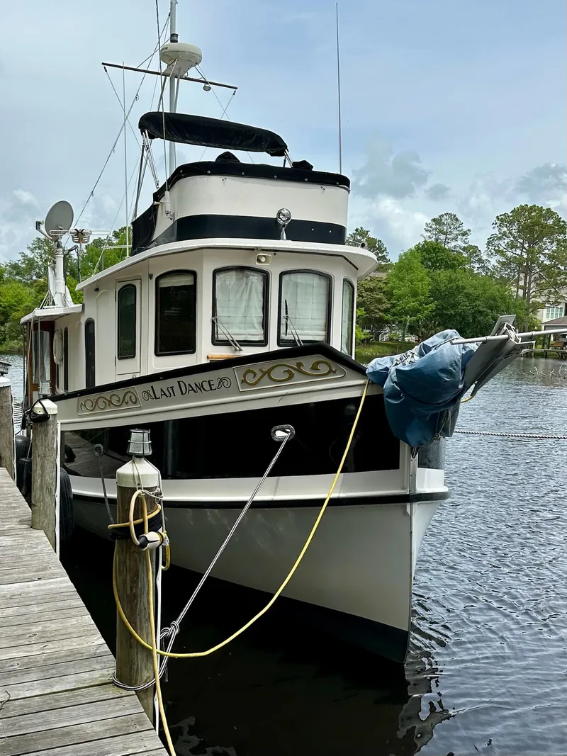Slide: The Image of 1989 Pilgrim Trawler docked by a serene riverside, surrounded by lush greenery. - 2