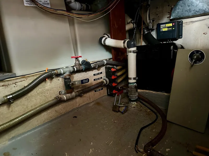 Slide: The Image of Engine room of a 1989 Pilgrim Trawler, featuring pipes, valves, and electrical components. - 27