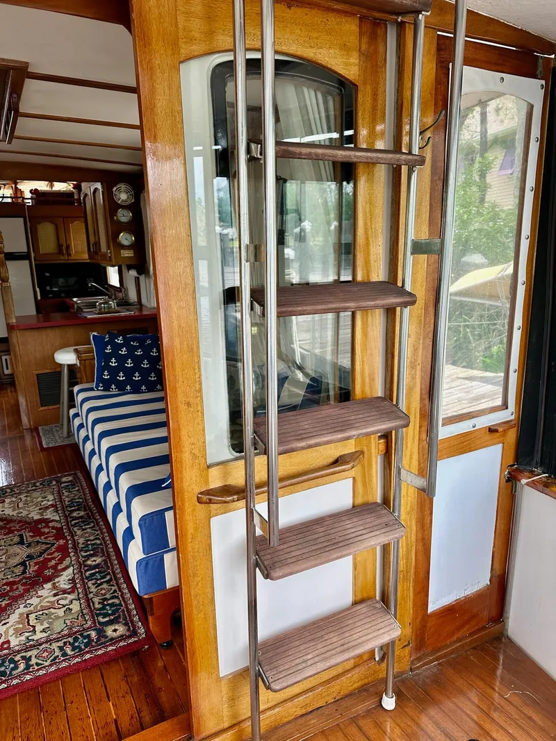 Slide: The Image of Interior of 1989 Pilgrim Trawler with wooden ladder, striped seating, and nautical decor. - 32
