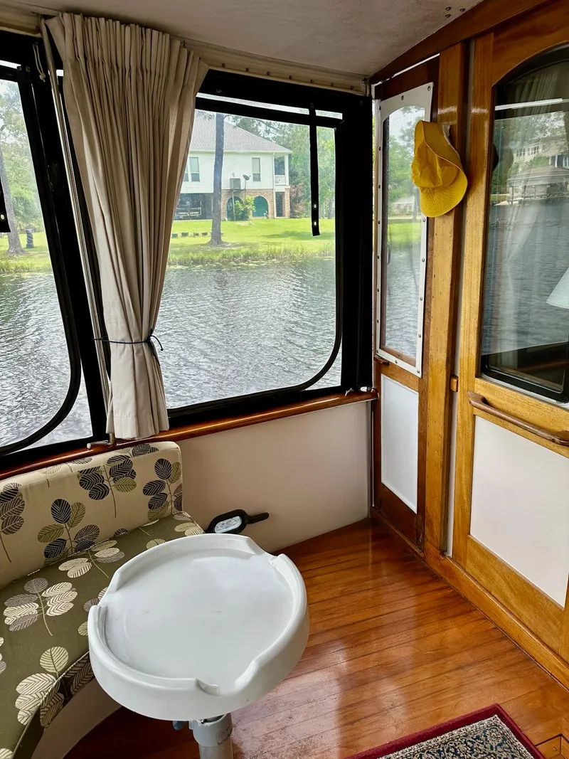 Slide: The Image of Interior of 1989 Pilgrim Trawler with lake view, floral seating, and wooden accents. - 34