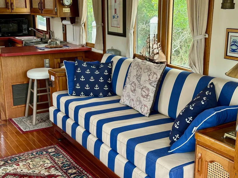 Slide: The Image of Cozy 1989 Pilgrim Trawler interior with nautical-themed decor and striped sofa. - 36
