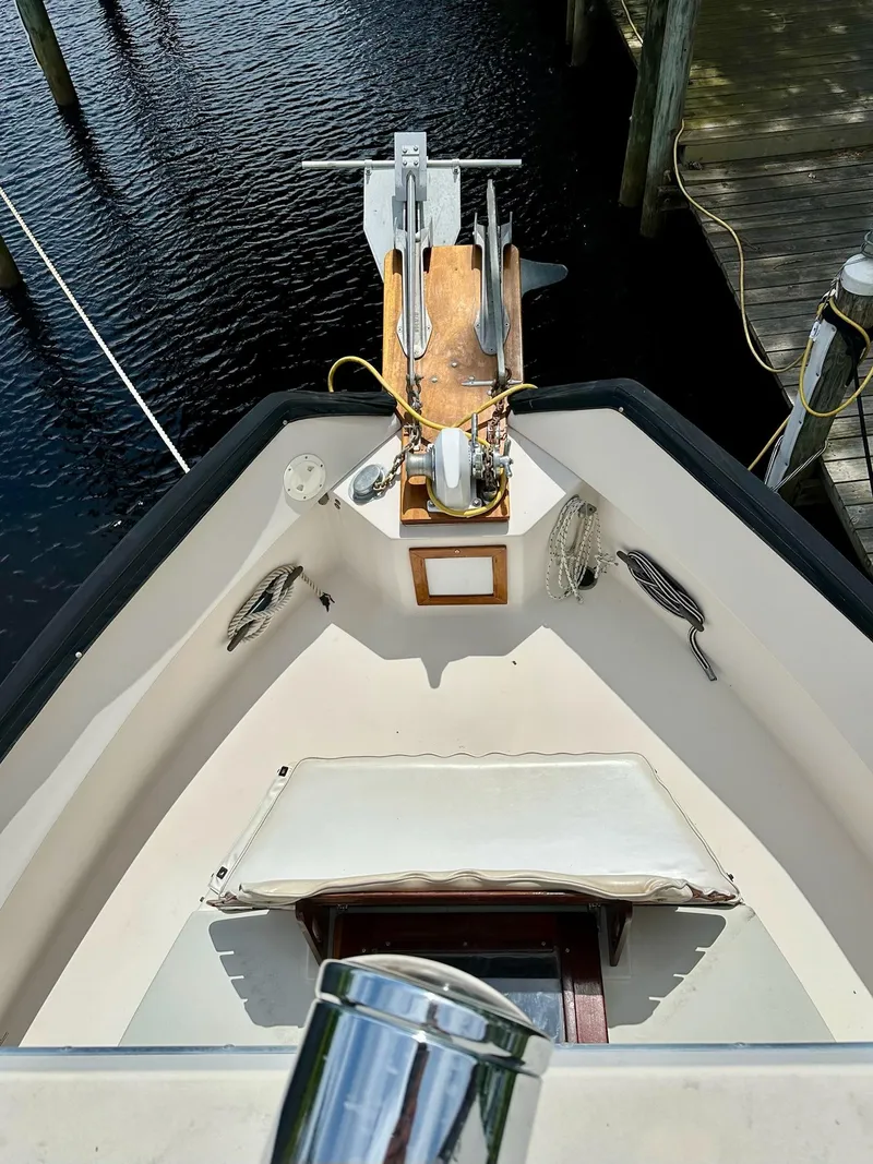 Slide: The Image of 1989 Pilgrim Trawler boat deck with anchor, docked by calm water. - 39