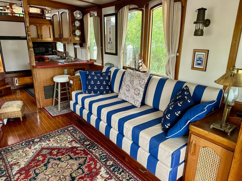 Slide: The Image of Cozy 1989 Pilgrim Trawler interior with striped sofa, nautical decor, and wooden accents. - 40