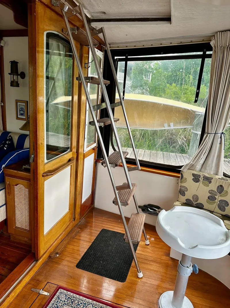Slide: The Image of Interior of 1989 Pilgrim Trawler with ladder, wooden flooring, and window view. - 42