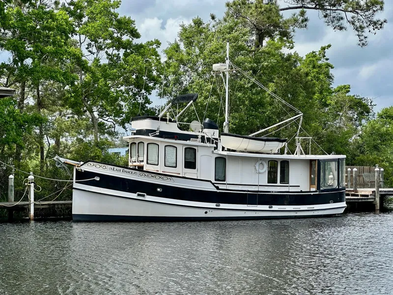 Slide: The Image of 1989 Pilgrim Trawler boat docked by lush greenery and calm water. - 45