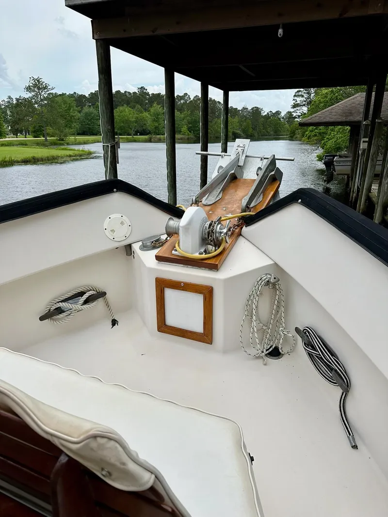 Slide: The Image of 1989 Pilgrim Trawler boat deck with anchor, ropes, and serene river view. - 5
