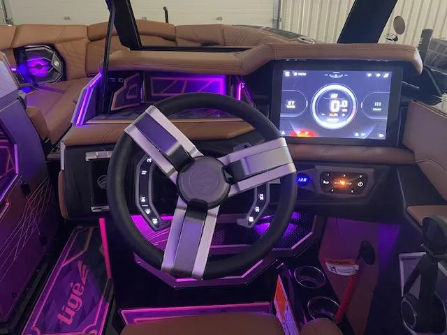 Slide: The Image of 2025 Tigé Ultré 25ZX boat interior with illuminated dashboard and modern steering wheel. - 3