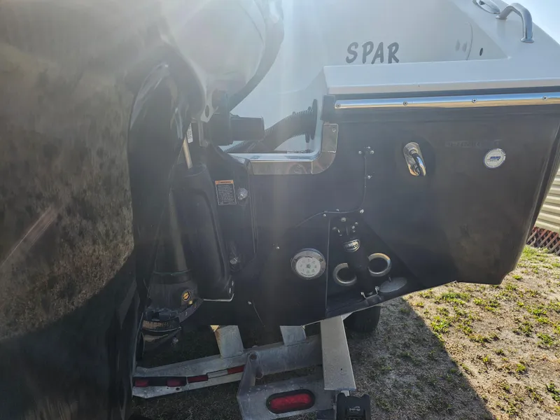 Slide: The Image of Rear view of a 2010 Triton 301 CC boat on a trailer, showing engine and hull details. - 12