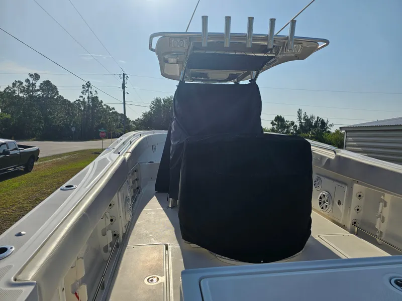 Slide: The Image of 2010 Triton 301 CC boat interior with covered console, rod holders, and speakers. - 13