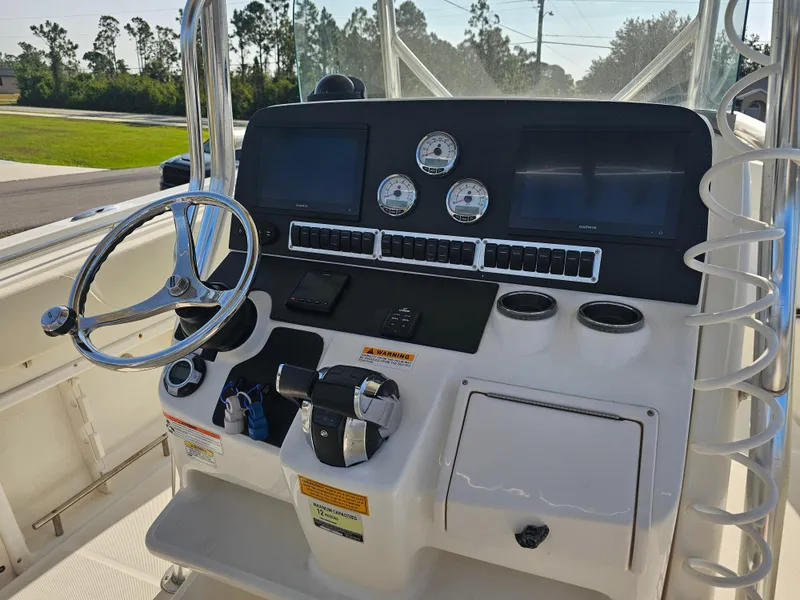 Slide: The Image of 2010 Triton 301 CC boat dashboard with steering wheel, gauges, and navigation screens. - 16