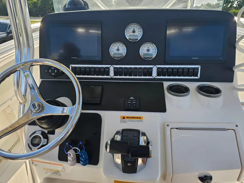 Slide: The Image of Control panel of a 2010 Triton 301 CC boat with steering wheel and gauges. - 17