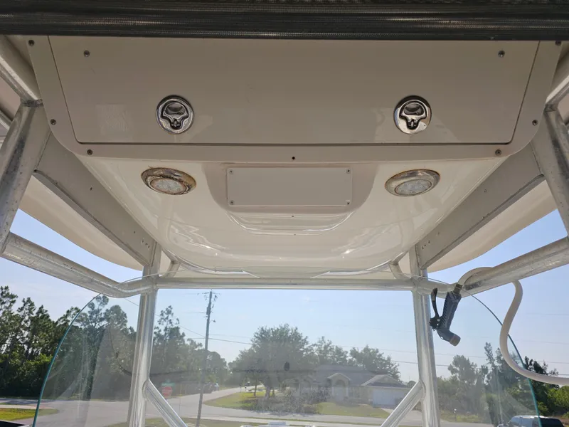 Slide: The Image of 2010 Triton 301 CC boat interior view with overhead storage and lighting. - 18