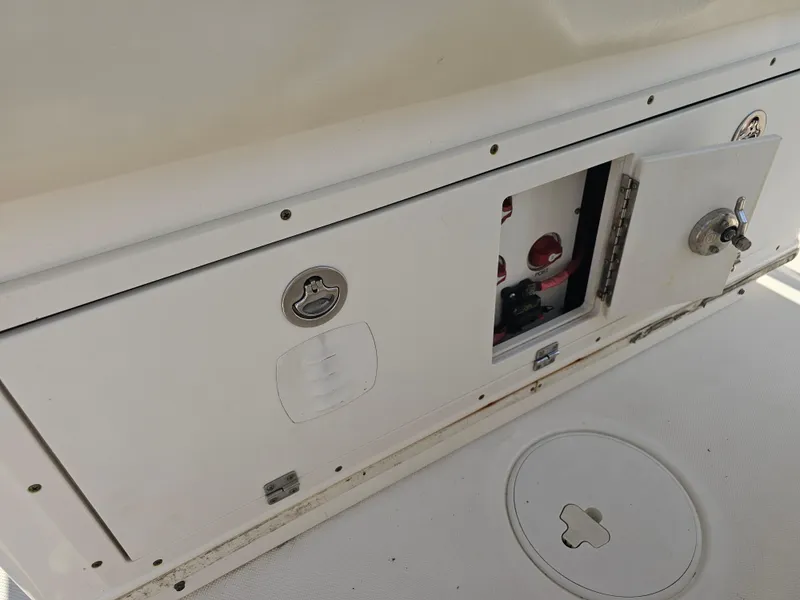 Slide: The Image of 2010 Triton 301 CC boat compartment with open access panel and visible controls. - 24