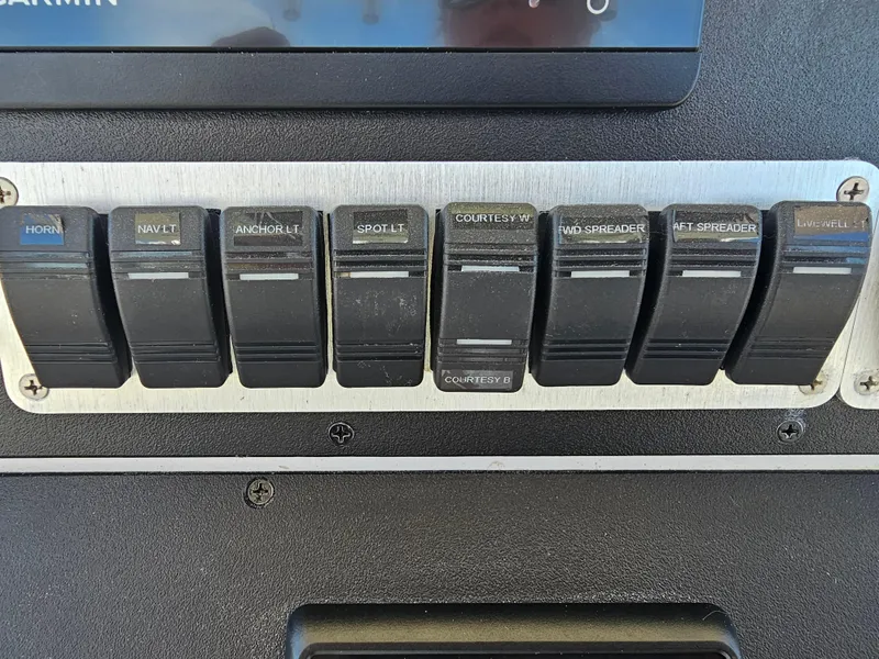 Slide: The Image of Control panel switches on a 2010 Triton 301 CC boat dashboard. - 25