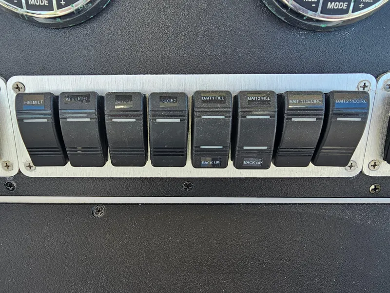 Slide: The Image of Control panel switches on a 2010 Triton 301 CC boat dashboard. - 26