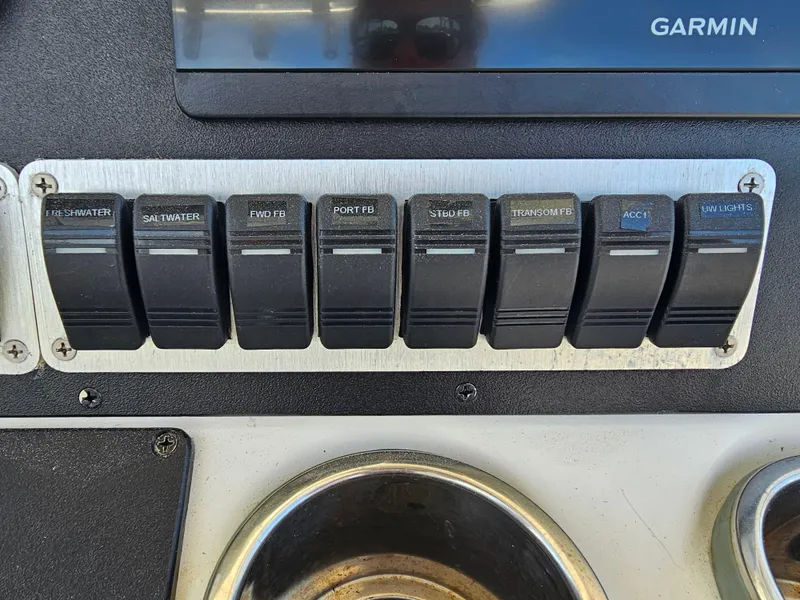 Slide: The Image of Control panel of a 2010 Triton 301 CC boat with labeled switches. - 27