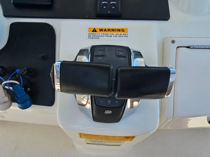Slide: The Image of Throttle controls on a 2010 Triton 301 CC boat dashboard with warning label. - 31