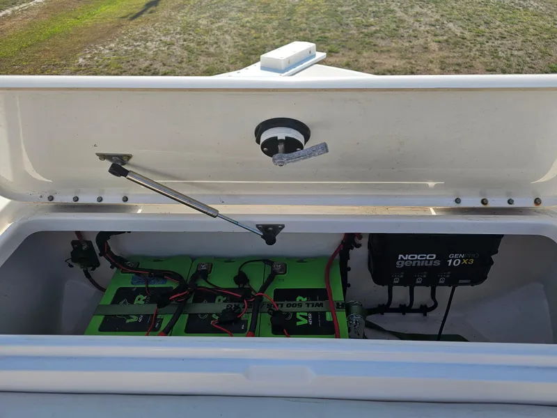 Slide: The Image of Triton 301 CC 2010 boat battery compartment with NOCO Genius charger and green batteries. - 36