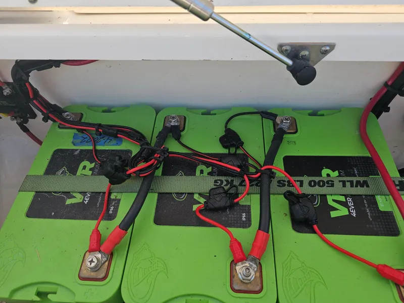 Slide: The Image of Green batteries with red and black cables in a Triton 301 CC boat, 2010 model. - 38