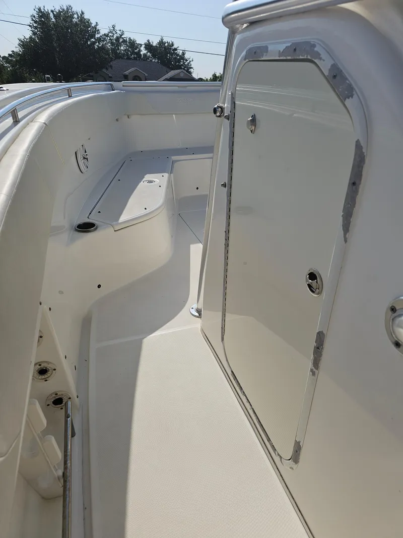 Slide: The Image of 2010 Triton 301 CC boat interior with white seating and storage compartment. - 42