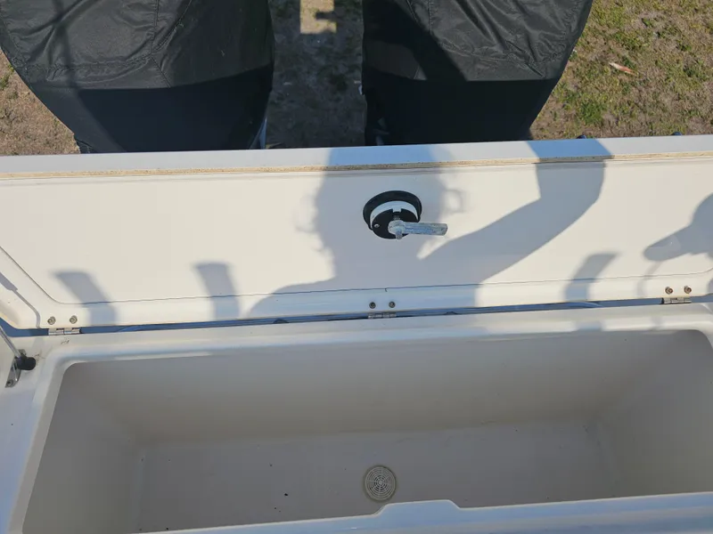 Slide: The Image of Open storage compartment on a 2010 Triton 301 CC boat, showing interior and latch. - 47