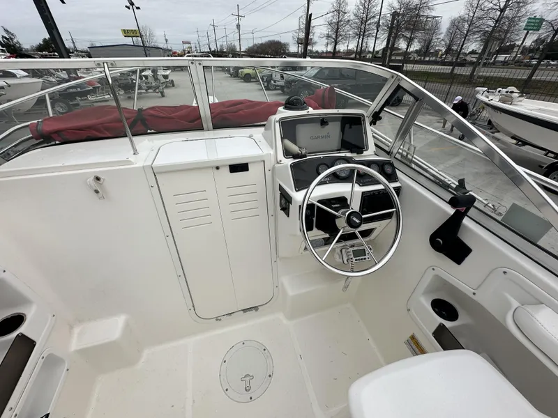 Slide: The Image of 1998 Boston Whaler 21 Conquest boat cockpit with steering wheel and Garmin navigation system. - 4
