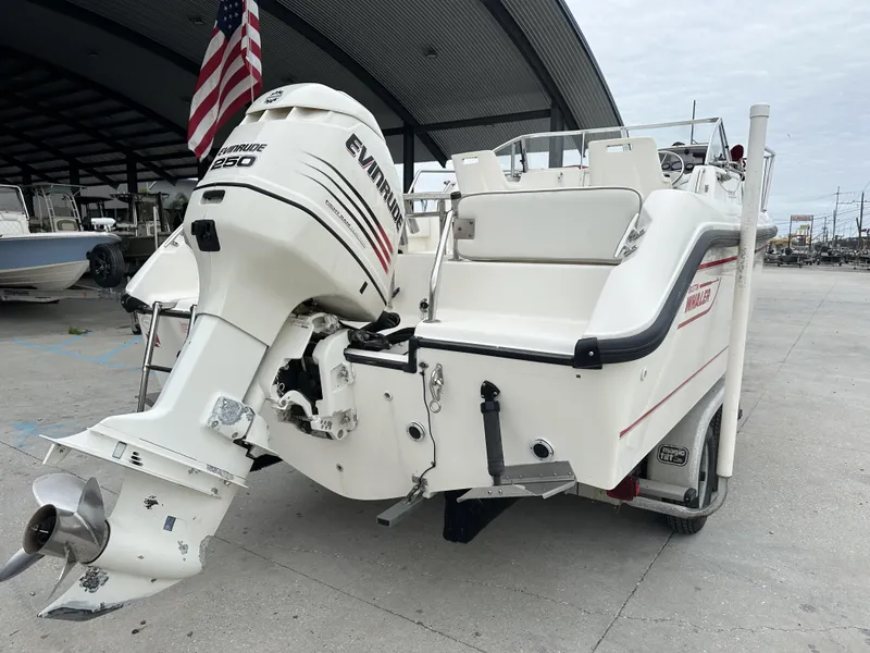 Slide: The Image of 1998 Boston Whaler 21 Conquest boat with Evinrude 250 outboard motor, docked under a canopy. - 9