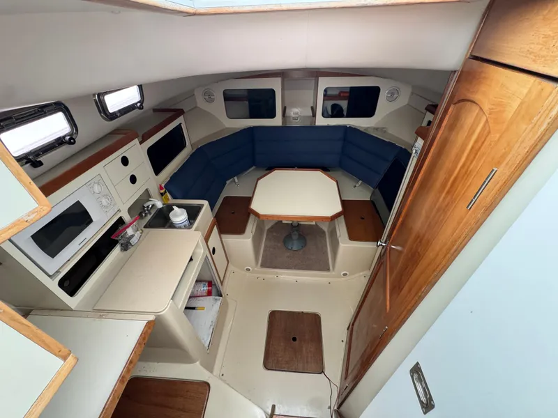 Slide: The Image of 2003 Albin 28 TE Flush Deck interior with seating, table, and kitchenette. - 19