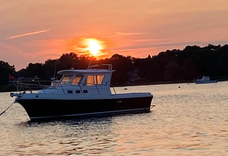 Slide: The Image of 2003 Albin 28 TE Flush Deck boat at sunset on calm water. - 2