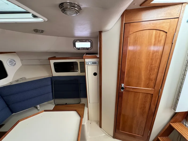 Slide: The Image of Interior of 2003 Albin 28 TE Flush Deck with wood accents and blue seating. - 23