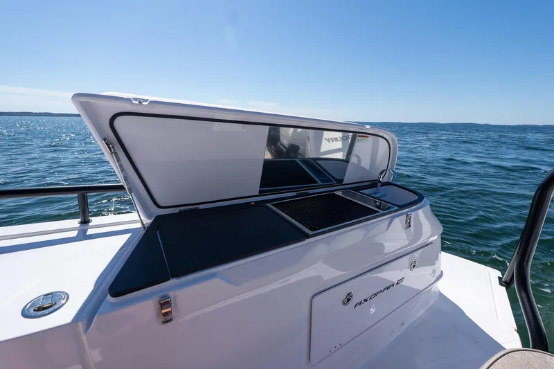 Slide: The Image of 2025 Axopar 45 boat with open storage compartment on a sunny day at sea. - 25