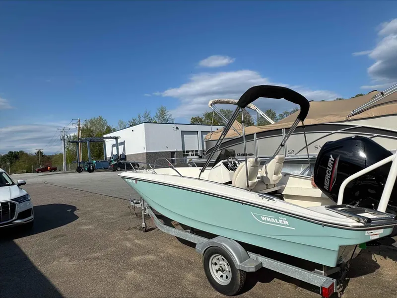Slide: The Image of 2020 Boston Whaler 160 Sport boat on trailer, parked outdoors under clear sky. - 1